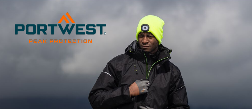 Imagem de um trabalhador com roupa de trabalho preta. O homem usa luvas e um bon&eacute; amarelo com luz LED incorporada. Ao fundo, s&atilde;o vis&iacute;veis nuvens escuras e uma paisagem enevoada.