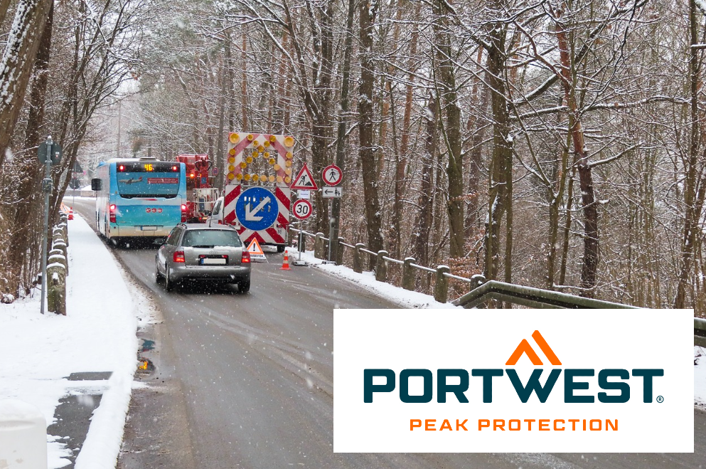 Cena de canteiro de obras com ônibus e carro em uma estrada nevada cercada por árvores. No canto direito encontra-se o logótipo da marca Portwest. Existe um link para a recolha de roupa térmica e frigorífica.