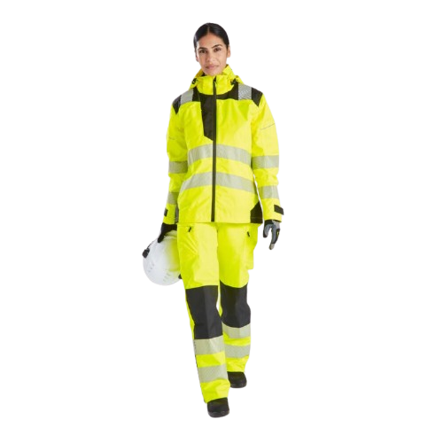 Mulher com vestu&aacute;rio de trabalho amarelo de alta visibilidade. Segura um capacete na m&atilde;o e olha diretamente para a c&acirc;mara. Existe um link para as cal&ccedil;as de chuva de alta visibilidade PW3 para senhora PW386.