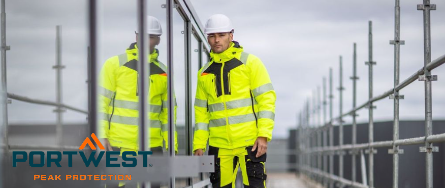 Um trabalhador com roupas de trabalho amarelas de alta visibilidade e um capacete branco em frente a uma janela. Você pode ver seu reflexo no vidro, e na metade direita da imagem você pode ver a extremidade superior de um andaime.