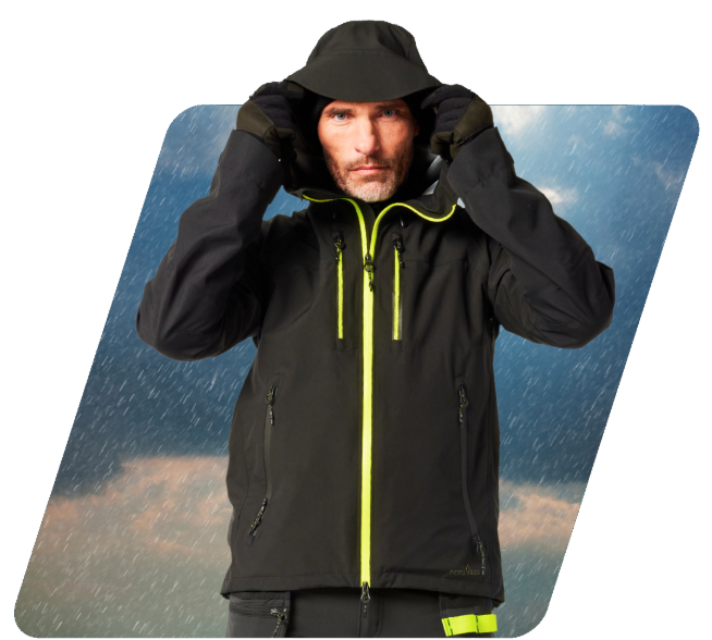 Um homem com barba a usar uma capa de chuva preta com detalhes em amarelo. Tem vestido um casaco softshell com capuz, calças a condizer e luvas. Um link para as nossas capas de chuva está incluído.